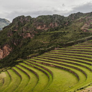 Ruínas incas no Vale Sagrado com montanhas ao fundo.
