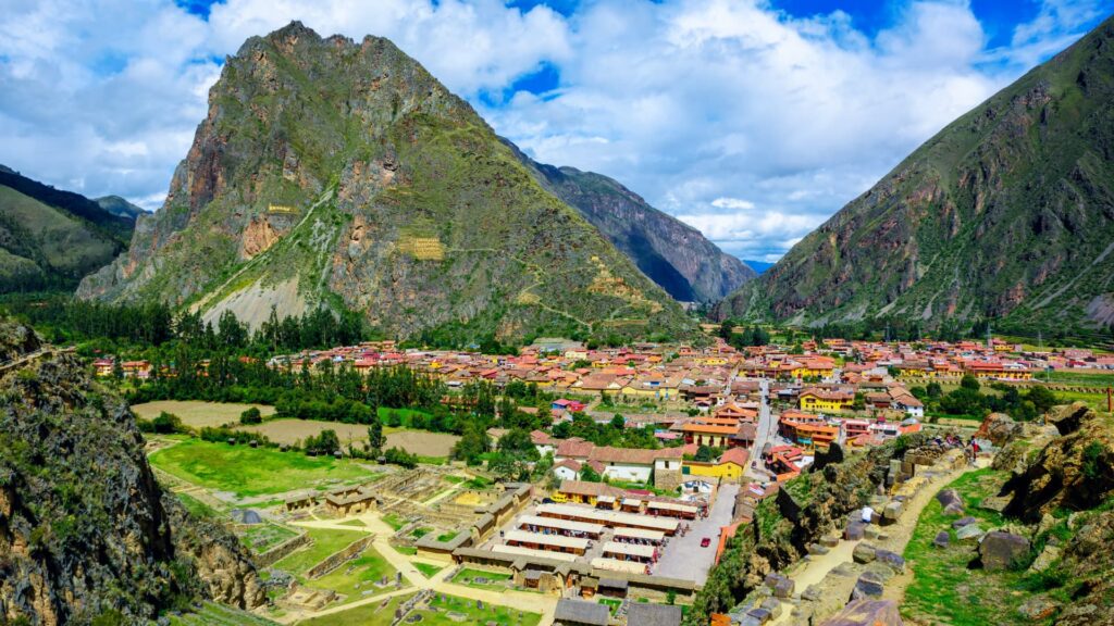 Stone terraces and ancient ruins at Ollantaytambo with a backdrop of towering mountains.
